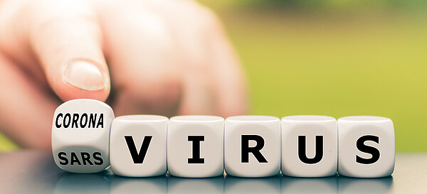 ©istockphoto.com Hand turns a dice and changes the expression "sars virus" to "corona virus".